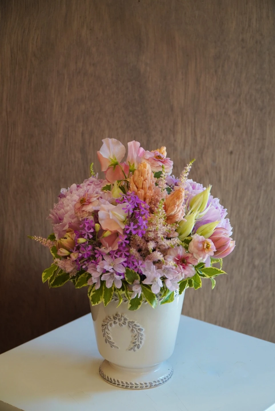 Soft pink and lilac flowers in a ceramic vessel